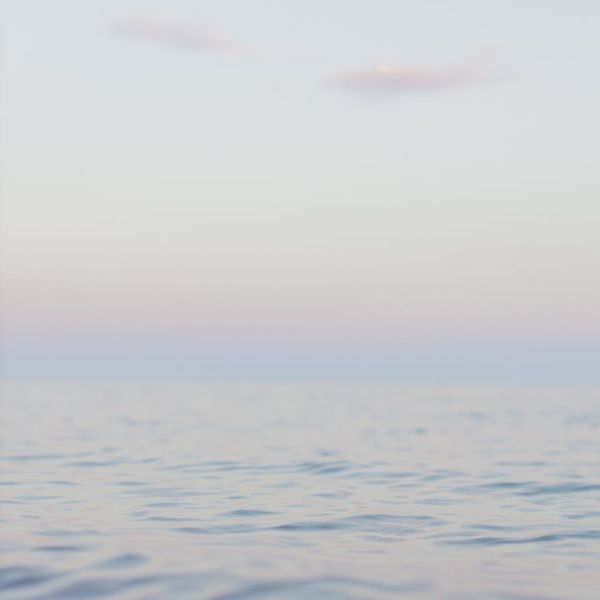 Man meditating peacefully outdoors with a serene natural background.