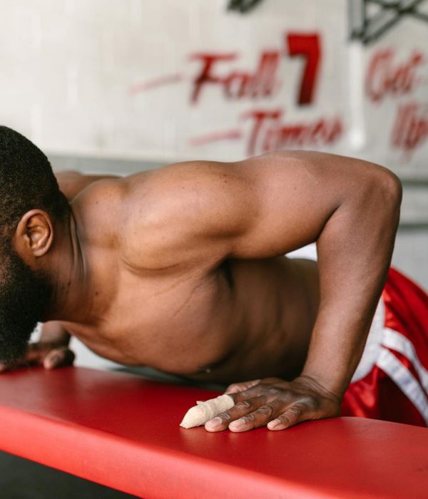 Man performing a bodyweight strength exercise in a modern gym.